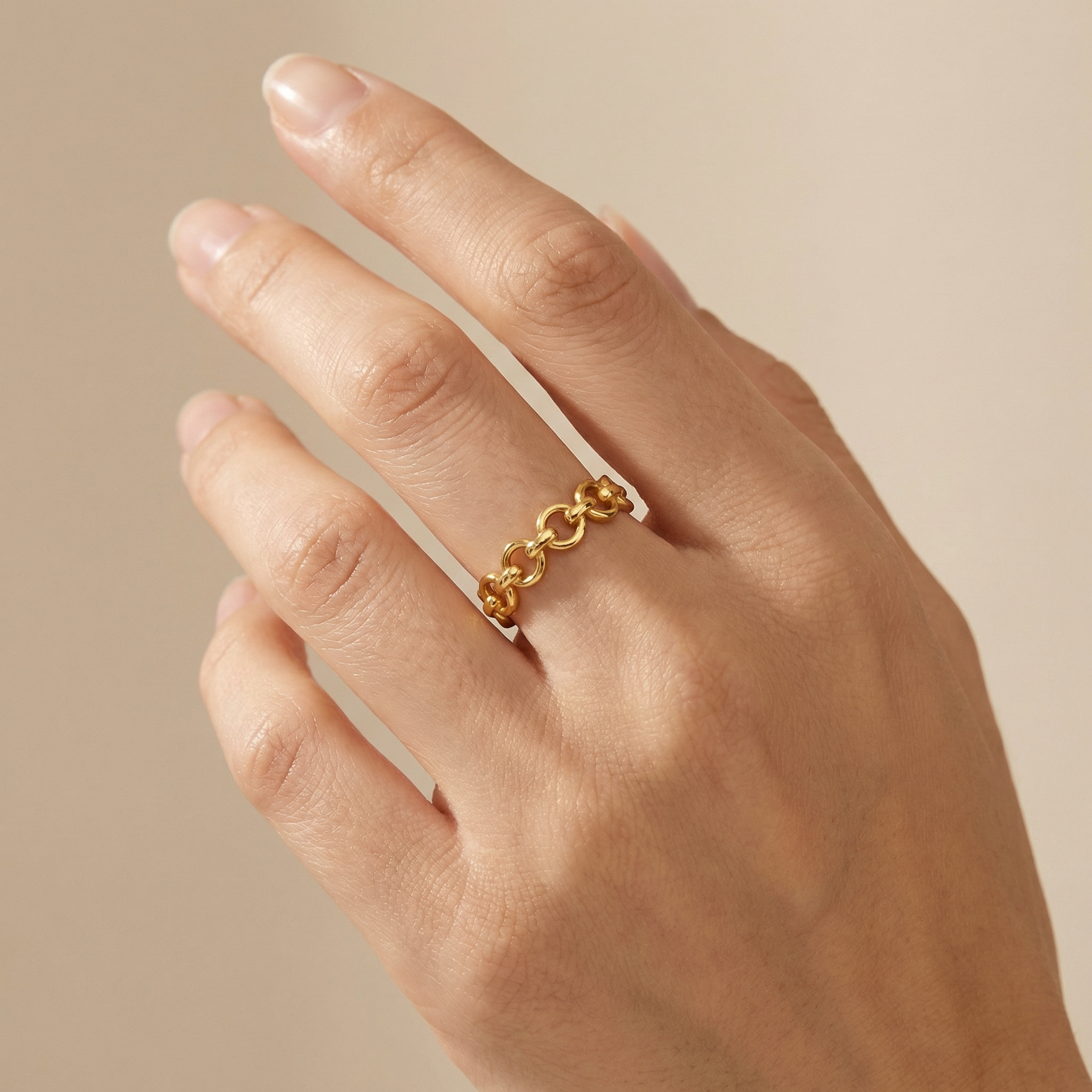 minimal gold interlocking link ring on white background