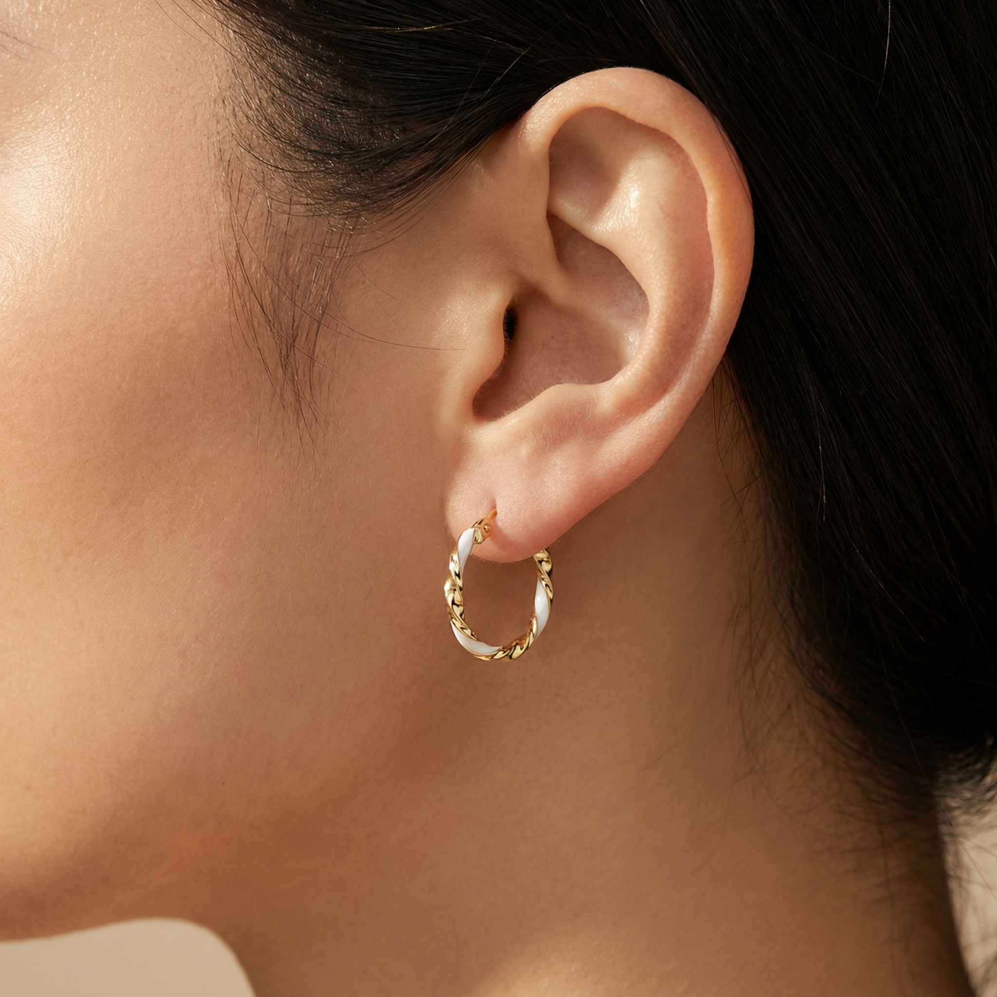 Elegant white and gold spiral hoop earrings close up