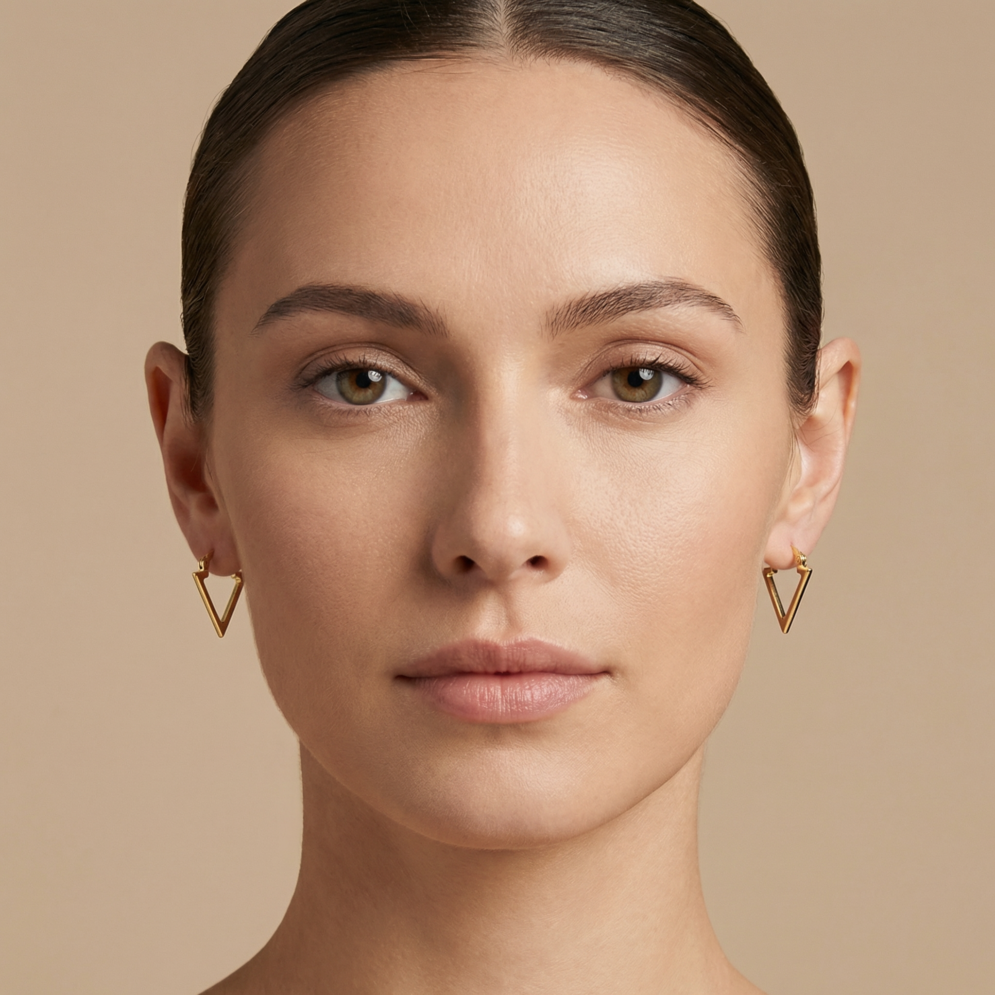 High polish 14k gold triangle hoops close up on white background