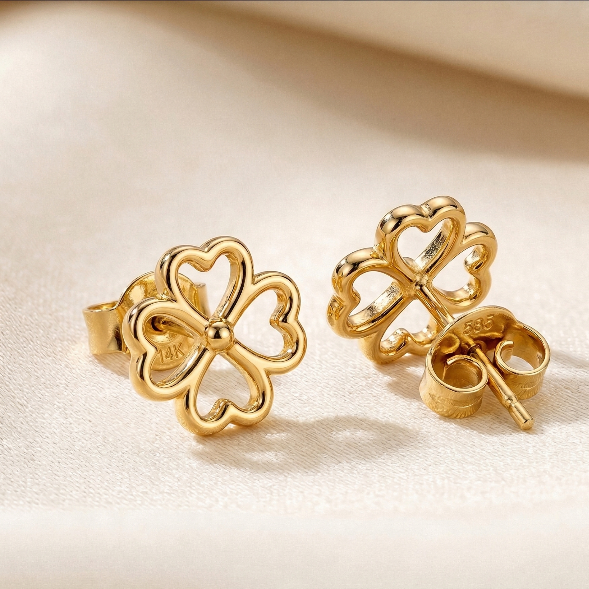 High-polish 14k gold minimalist clover earrings on white background