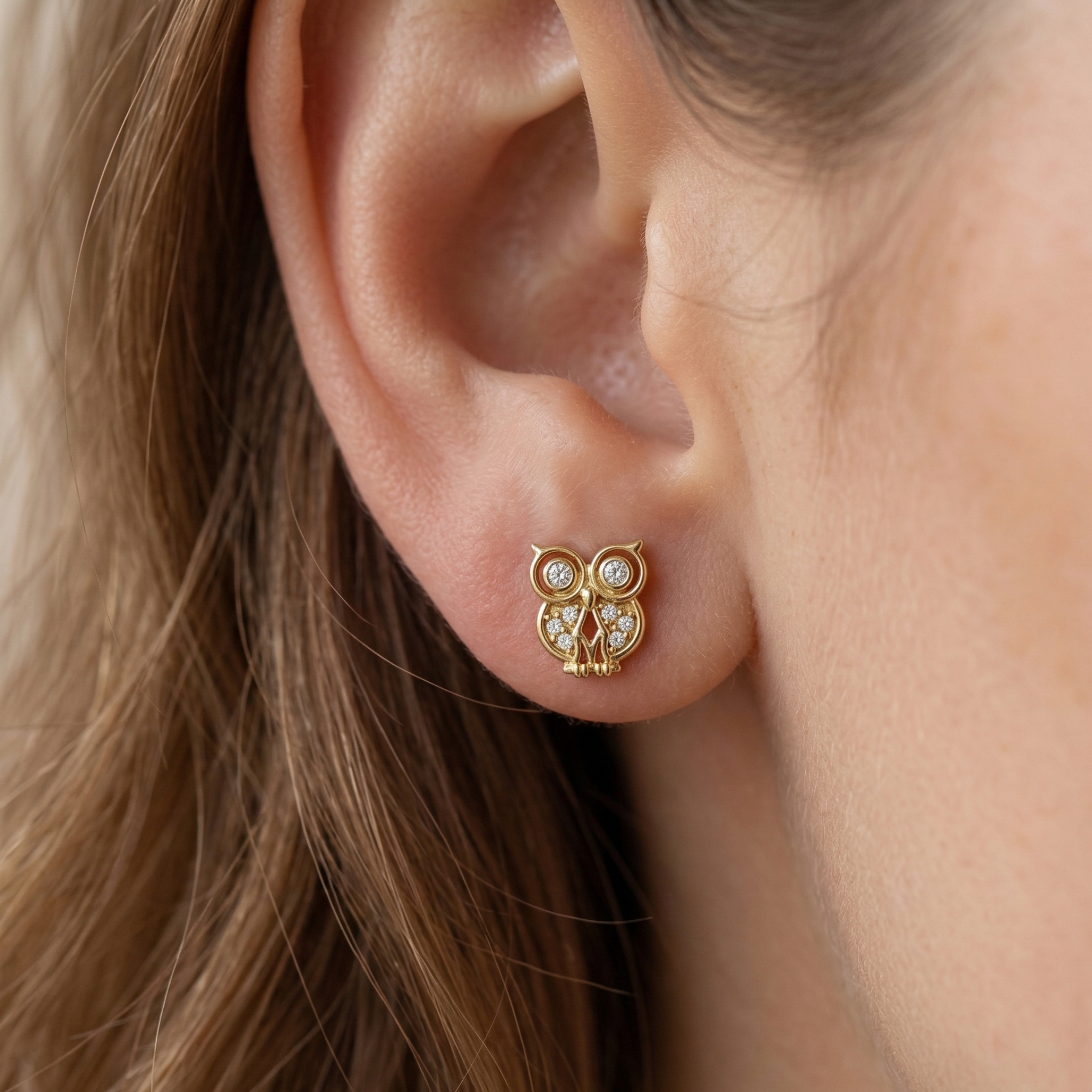 High-polish 14k gold animal earrings with shimmering detail on white background