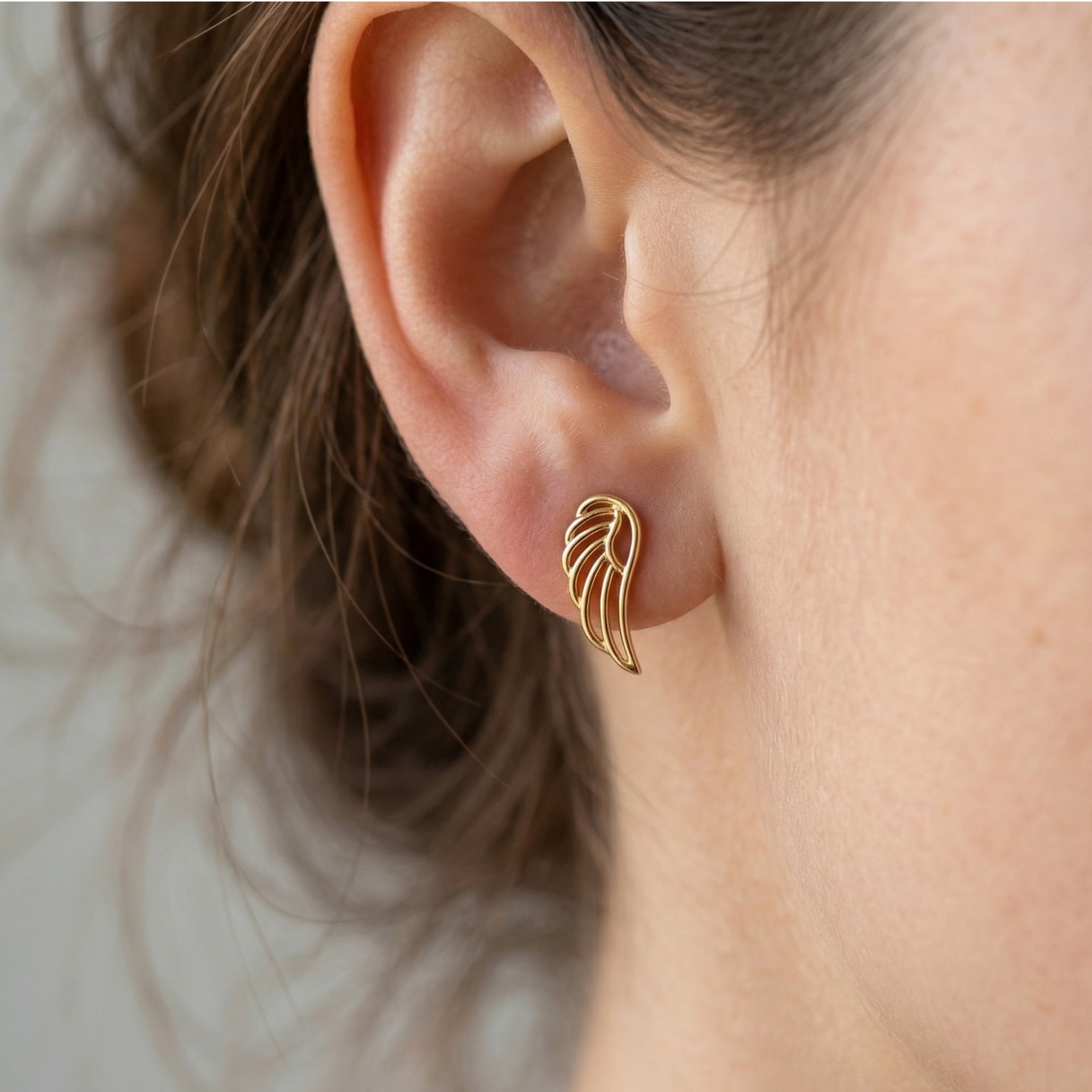 High-polish 14k gold symbolic feather earrings for women on white background