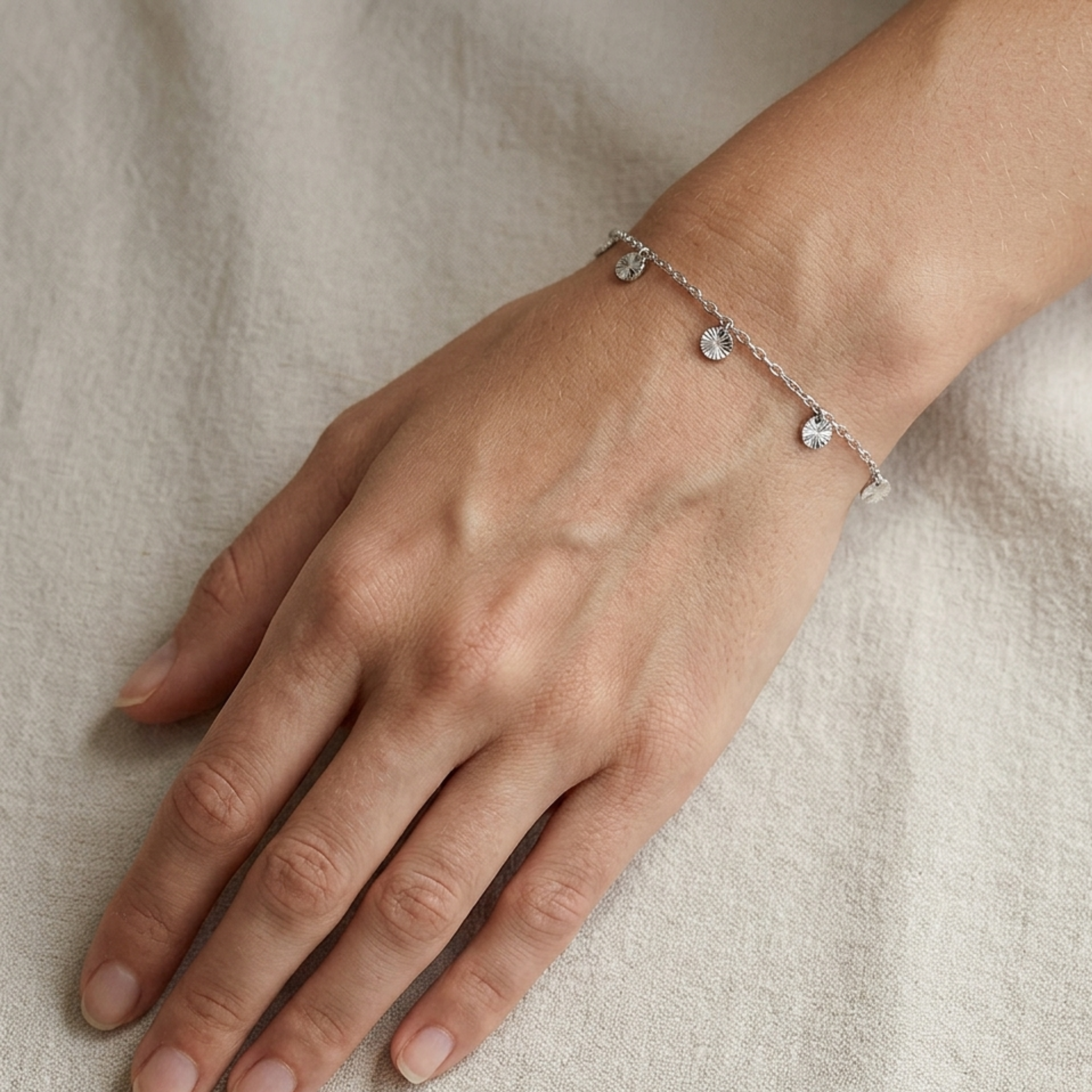 14k white gold bracelet on a person's wrist against a neutral background