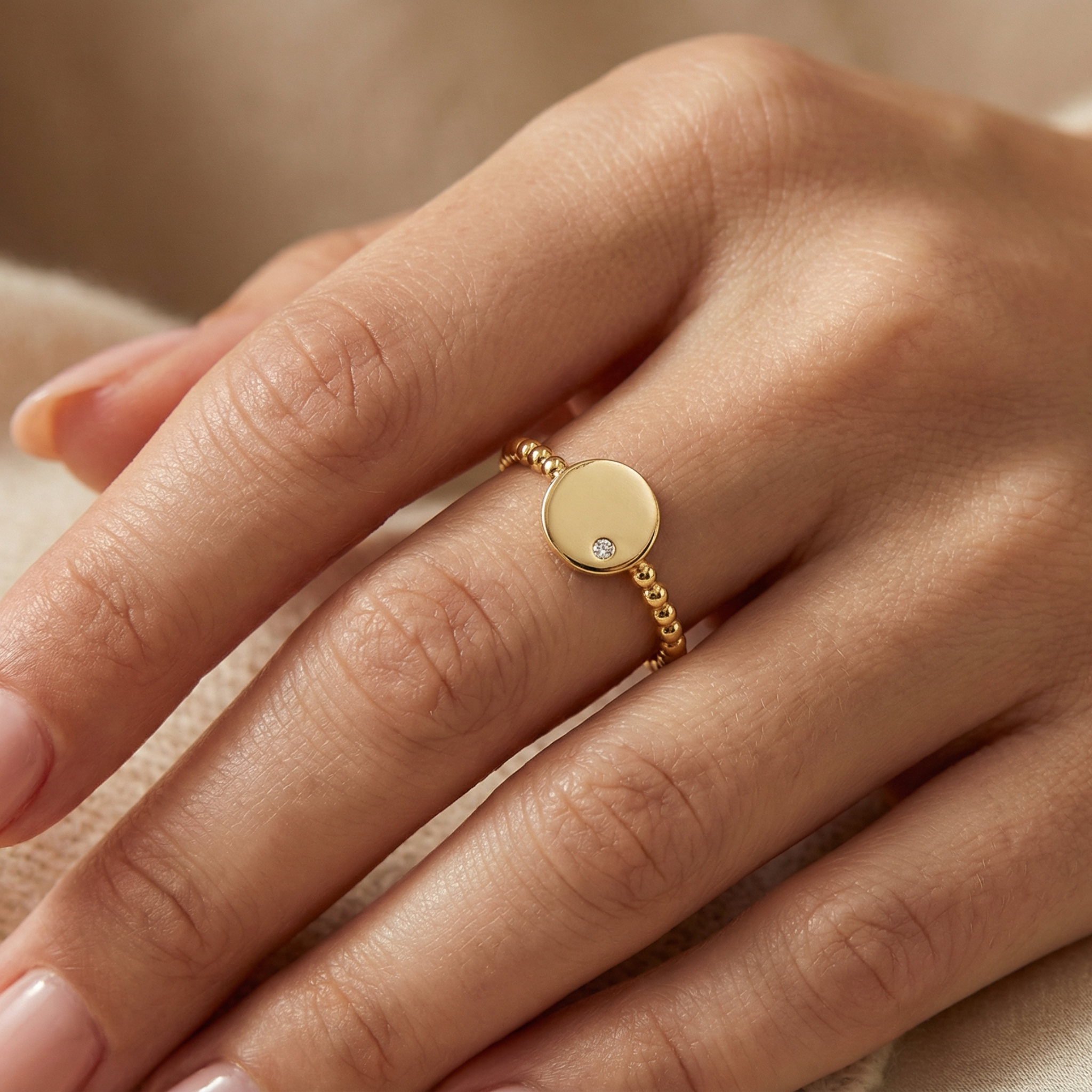 14K solid gold engravable disc ring with diamond accent worn on female finger