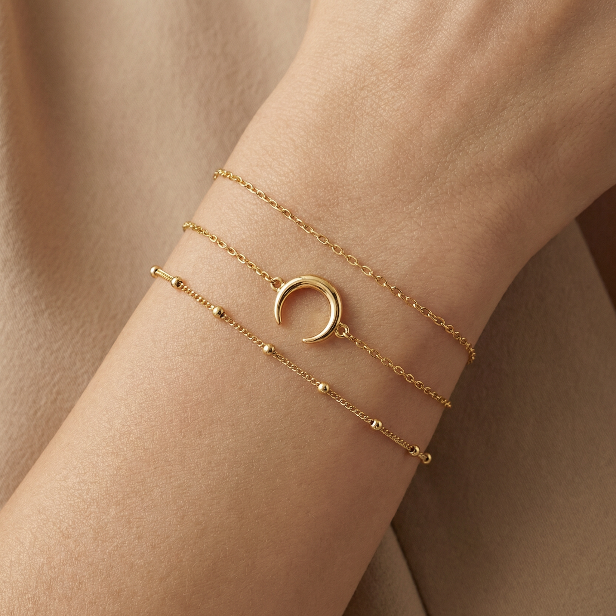 dainty 14k gold crescent charm bracelet worn on wrist, soft feminine styling