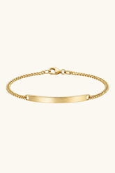 Gold bracelet with a plain tag on a white background