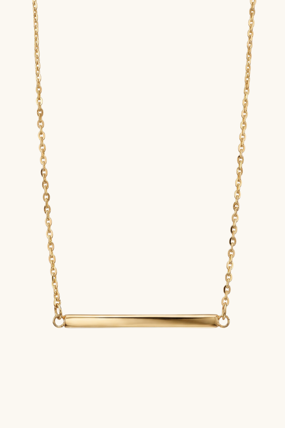 Gold necklace with a bar pendant on a white background