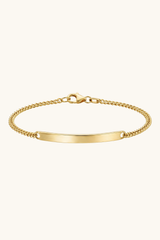 Gold bracelet with a plain tag on a white background