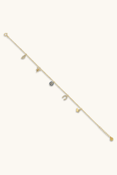Delicate gold bracelet with small gemstones on a white background