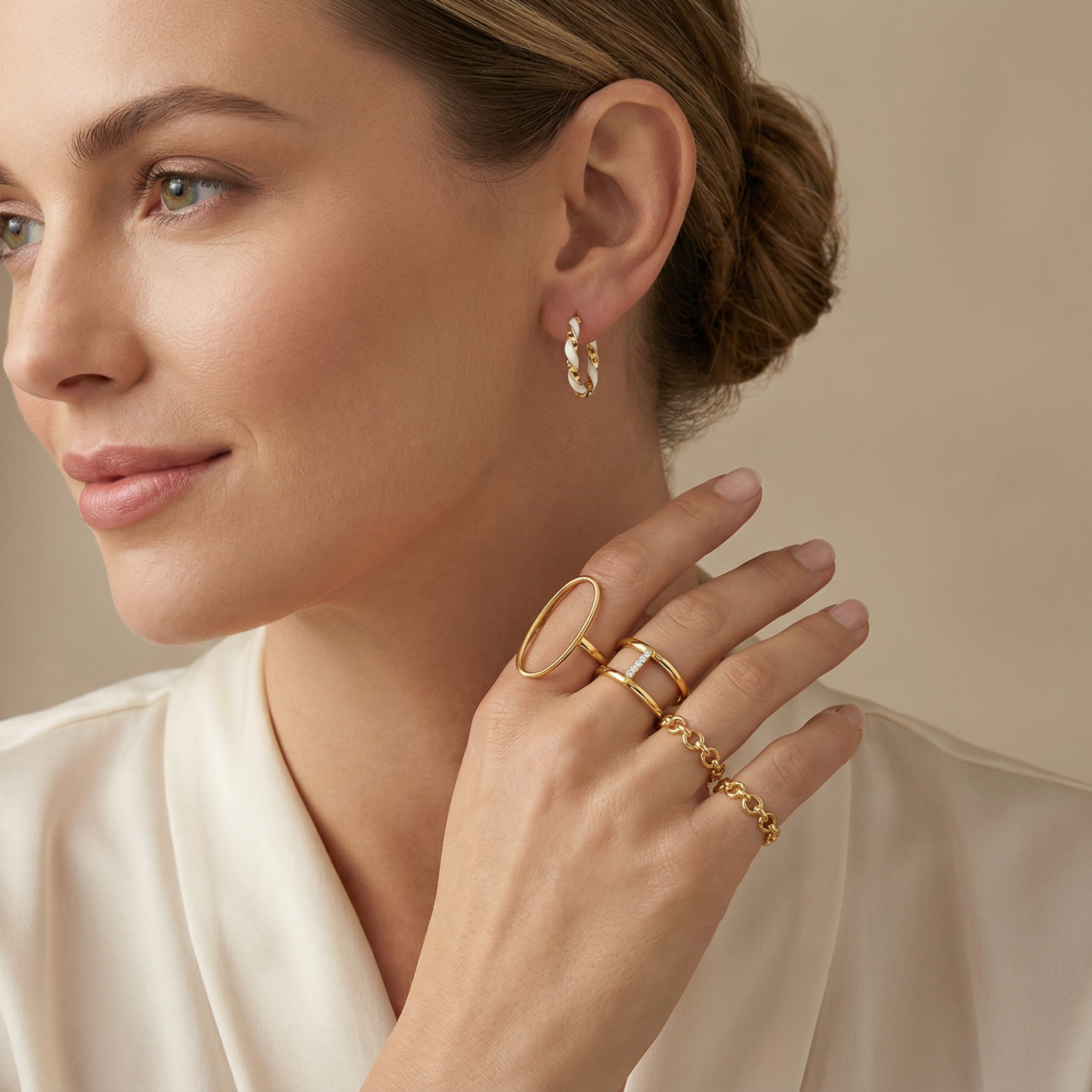 Modern twisted gold hoops featuring creamy white enamel detail