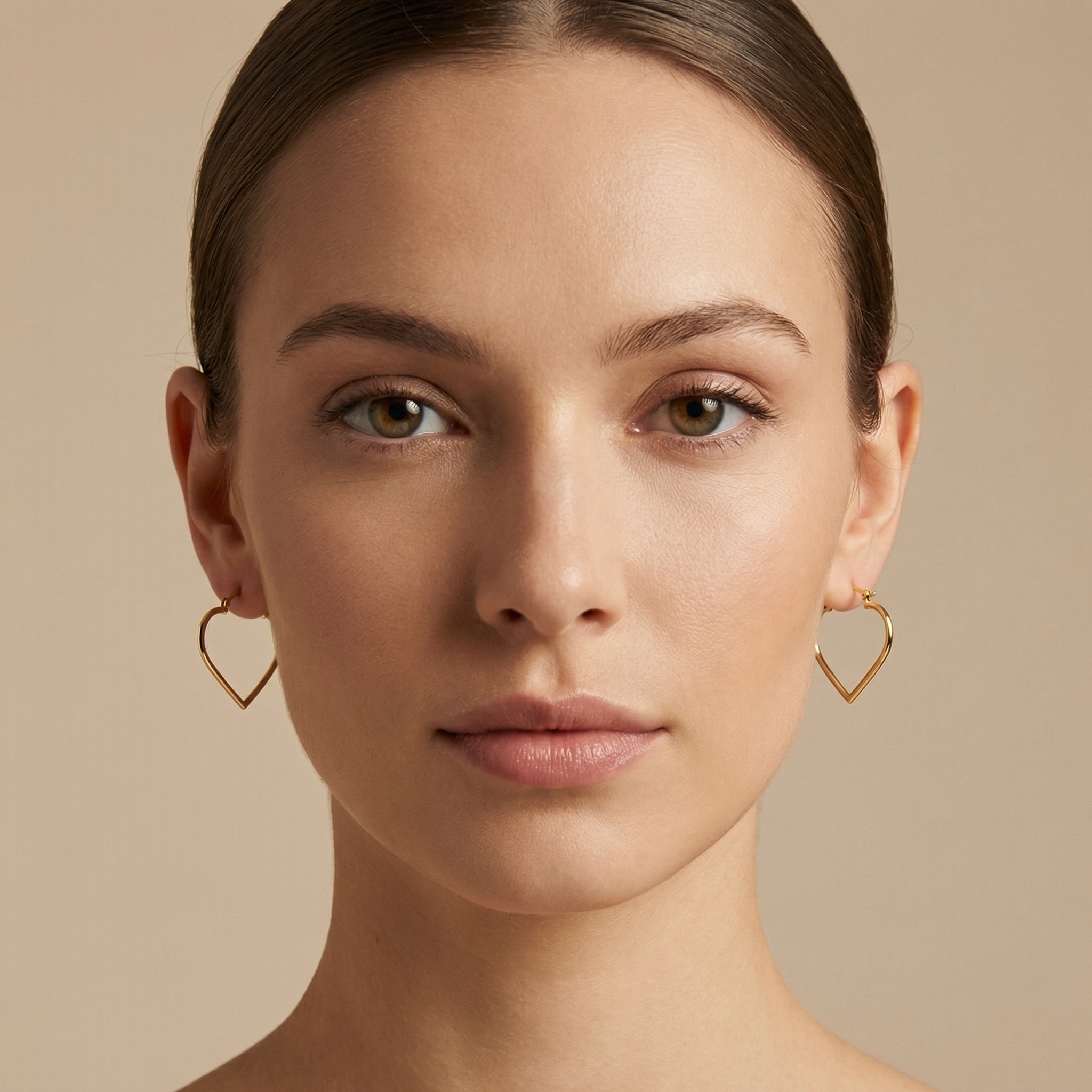 High polish 14k gold heart hoops close up on white background