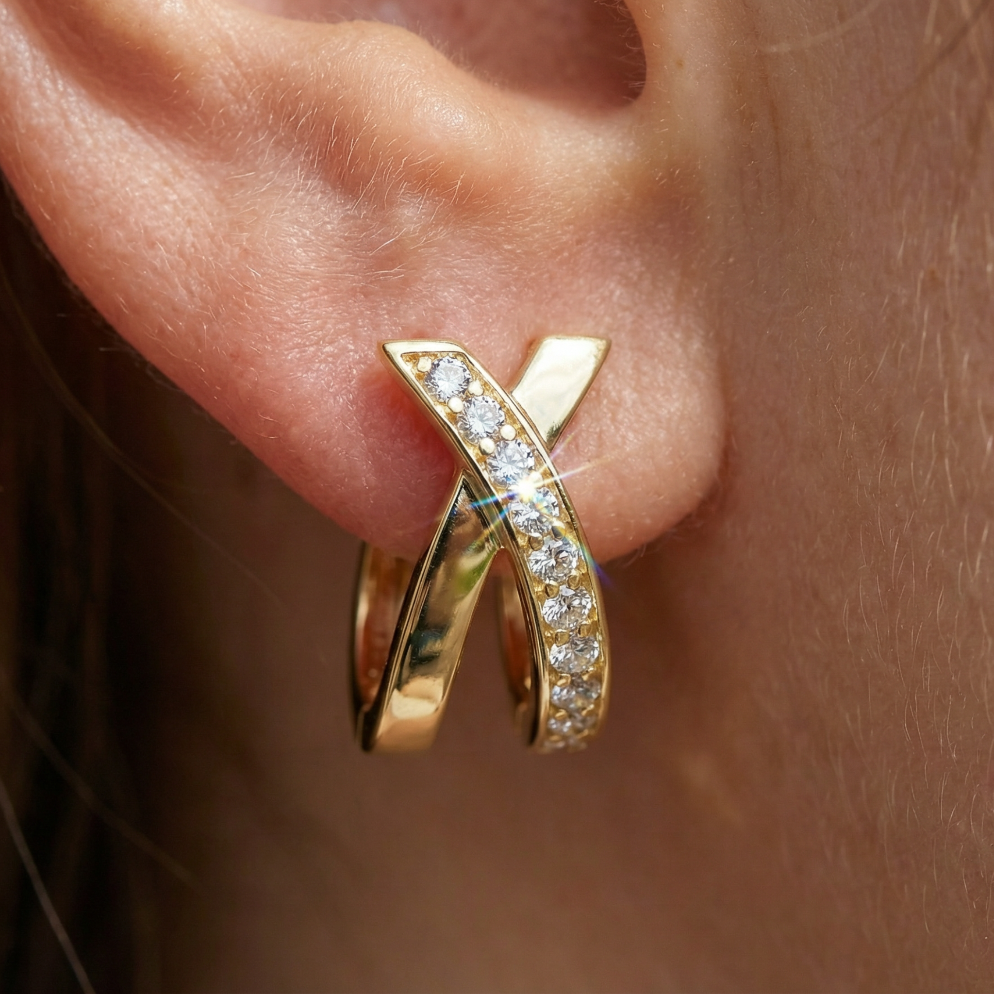 Gold earring with diamonds worn on an ear