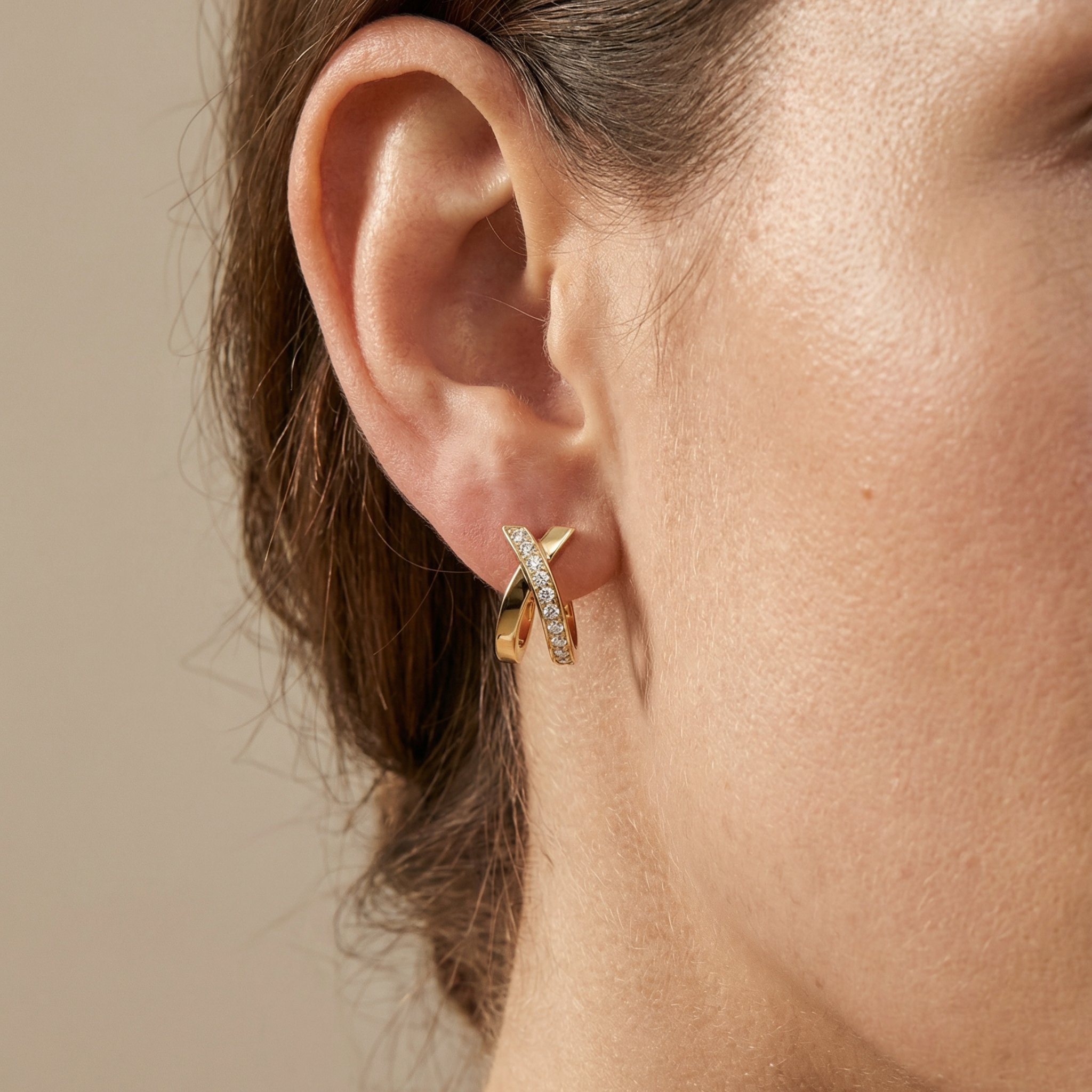 Gold earring worn by a person with a neutral background