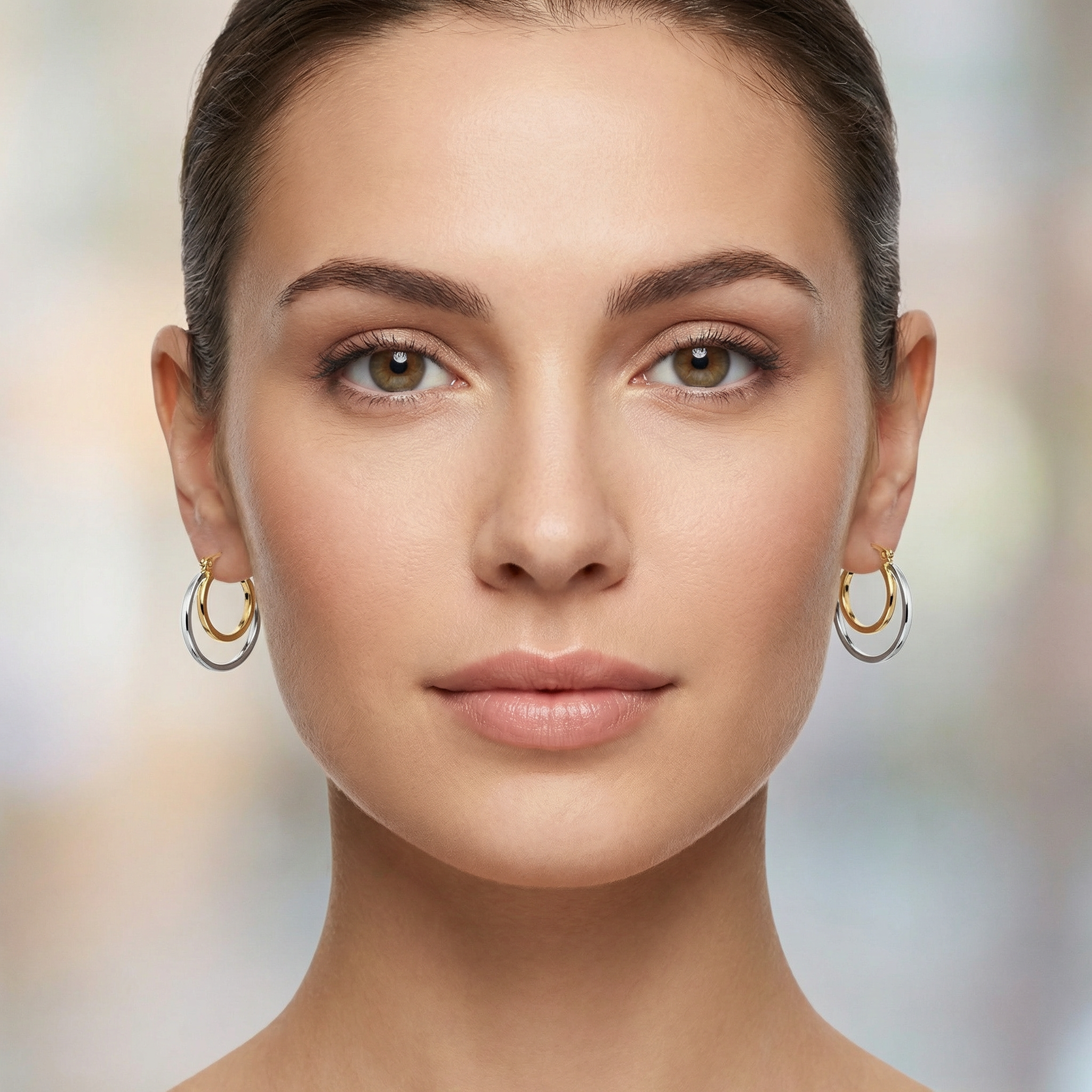 Close-up of a woman wearing gold hoop earrings with a blurred background