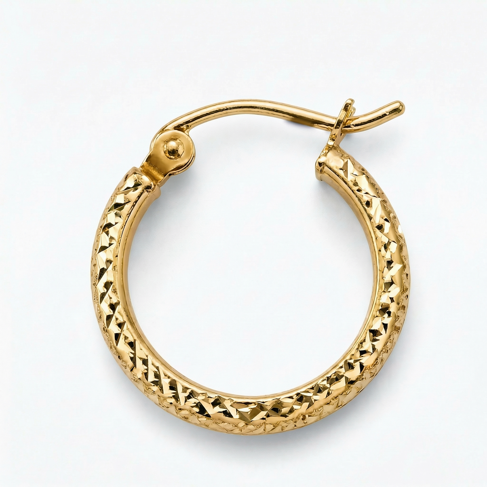 Gold hoop earring with textured design on a white background